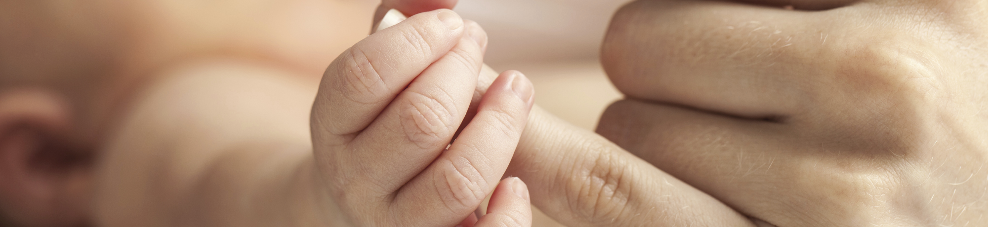 baby holding adult finger